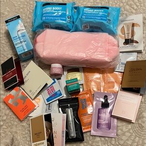 Lot of hair care, skin care, and fragrance samples with light pink make up bag